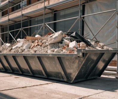 Bauschuttmulde gefüllt mit Betonbruch, Ziegeln und Porenbeton auf einer Baustelle mit Gerüst