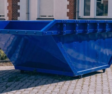 Leere blaue Absetzmulde vor einem Wohnhaus, mietfertig – Mulde mieten in Wien, Niederösterreich und Burgenland